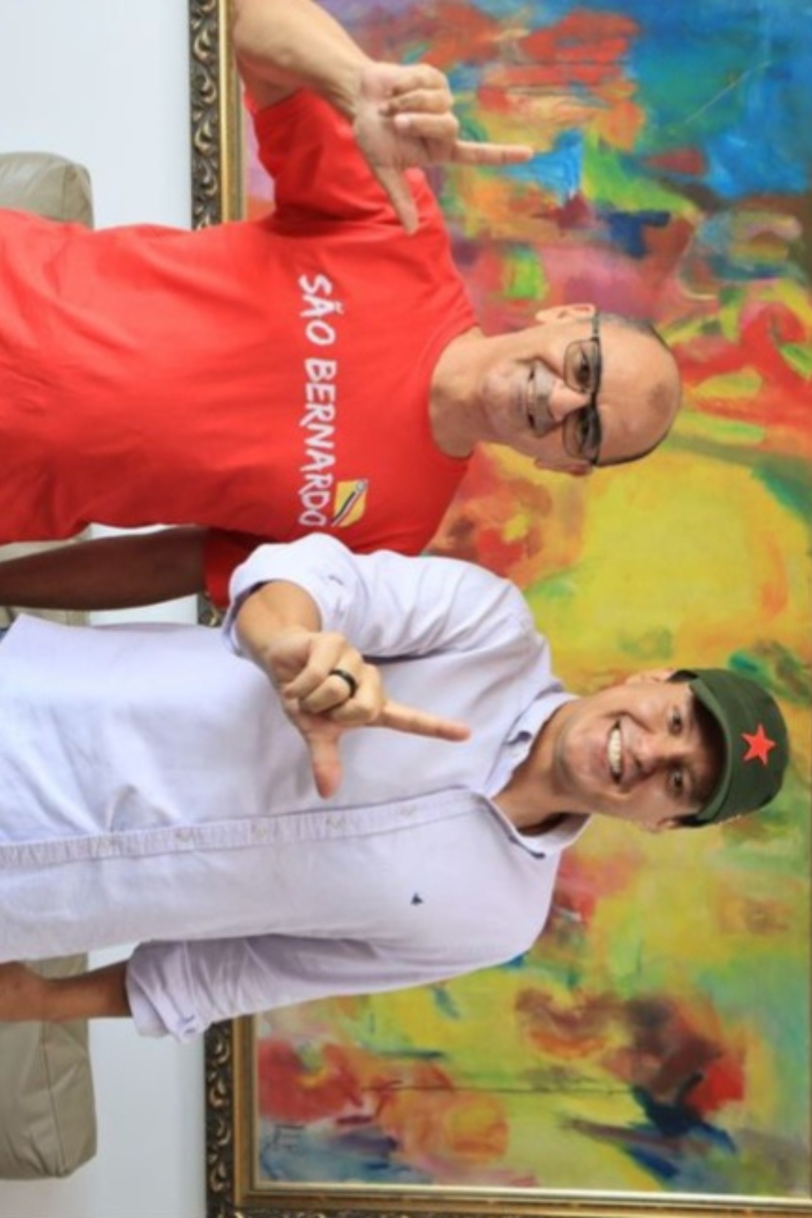 Gilvan ao lado de Felipe Camarão, ambos fazendo o gesto da letra L.